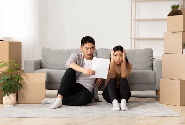 couple sitting on the floor looking worried