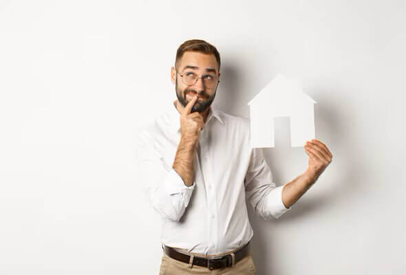 man thinking while holding a model house