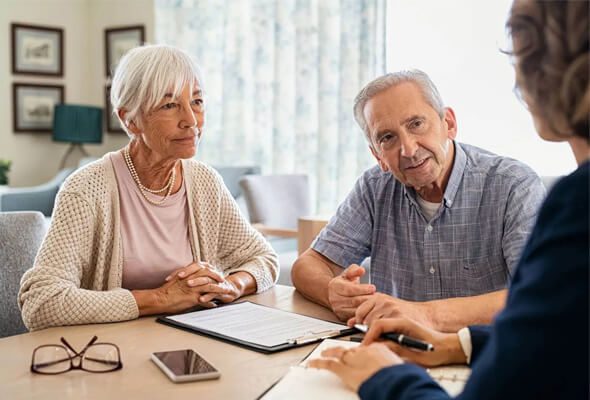 elderly couple talking to mortgage broker