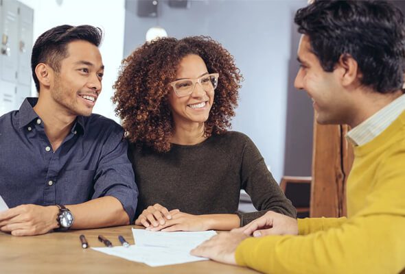 young couple talking to mortgage lender about buyout loan